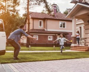 Daughter running to father on front lawn